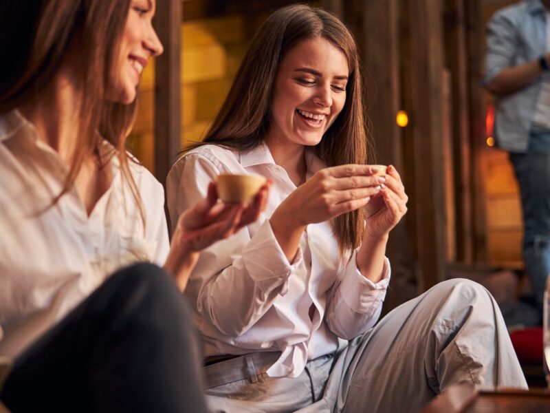 Cheerful young women drinking tea in cafe