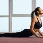 Flexible girl doing yoga pose on yoga mat.