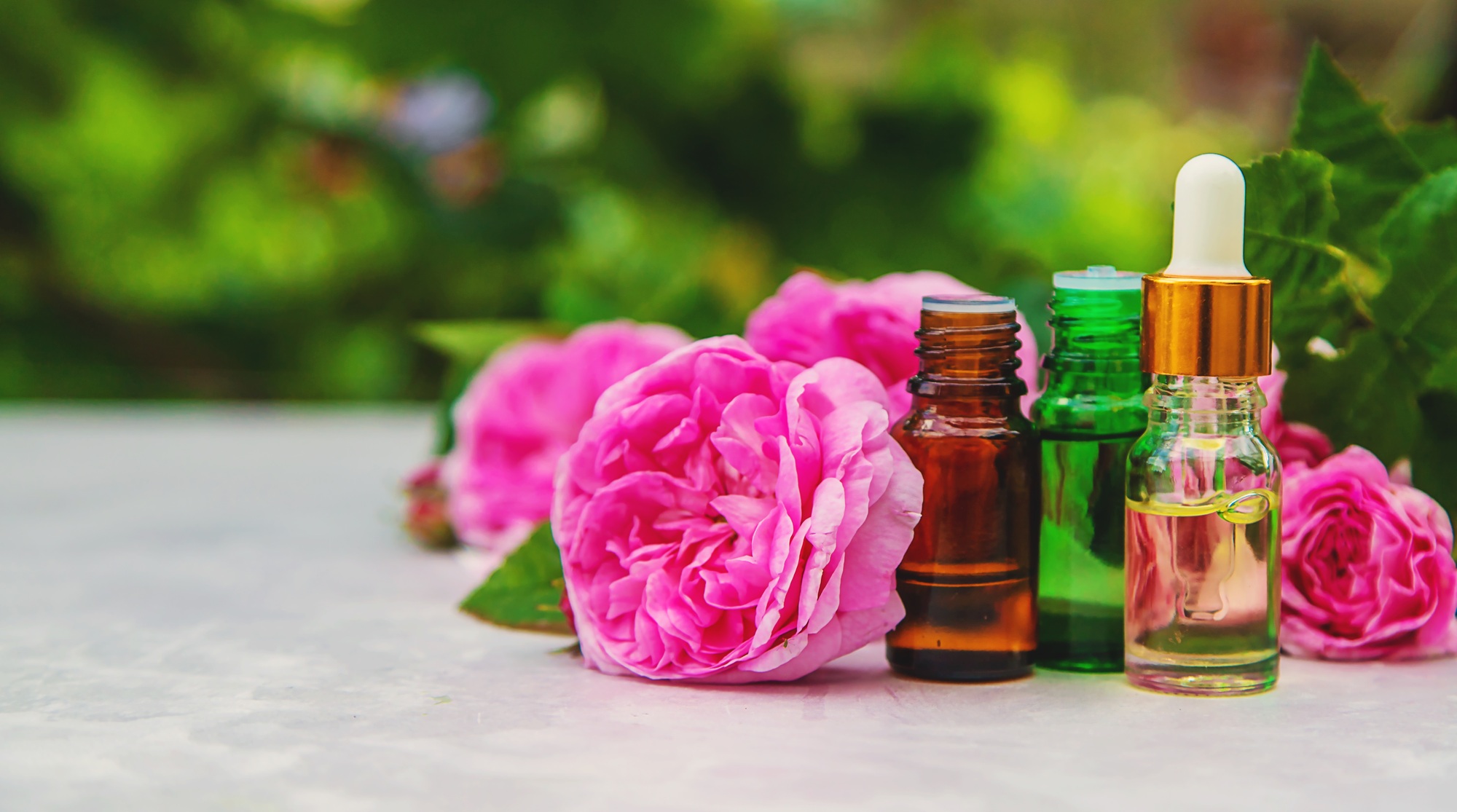 Rose essential oil in a bottle. Selective focus.
